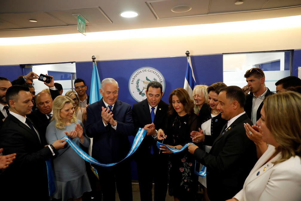 Hilda Patricia Marroquin, mulher do presidente da Guatemala Jimmy Morales, corta a fita para inaugurar a embaixada da Guatemala em Jerusalém ao lado se seu marido e do premiê israelense Benjamin Netany nesta quarta-feira (16) (Foto: Ronen Zvulun/Pool/Reuters)