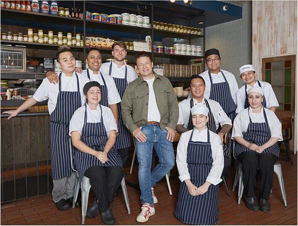 O chef e apresentador de TV Jamie Oliver com funcionários de uma unidade de seu restaurante (Foto: Instagram)