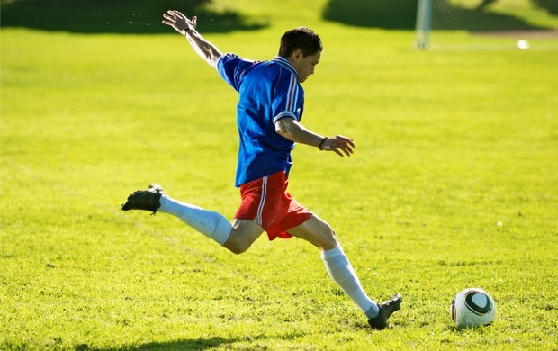 Pé Do Jogador De Futebol Na Bota Do Futebol Na Bola Foto de Stock