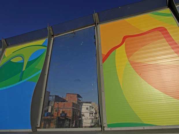 Posters dos Jogos Olímpicos Rio 2016 são colocados na Linha Vermelha, perto do complexo de favelas da Maré, que liga o Aeroporto Internacional do Rio de Janeiro com o centro e a zona sul da cidade  (Foto: Ricardo Moraes/Reuters)