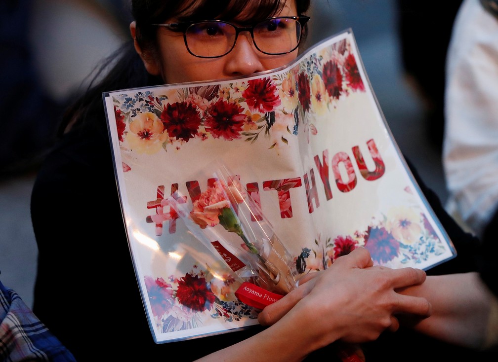Manifestante segura cartaz com a hashtag #WithYou ("com você", em português) durante protesto nesta terça-feira (11) em Tóquio. — Foto: Issei Kato/Reuters