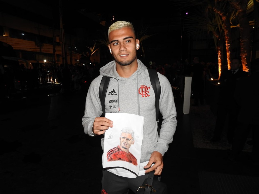 Andreas com o presente que recebeu da torcedora em Curitiba, na chegada do Flamengo — Foto: Fred Gomes / ge