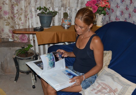 Glecigenes mostra o álbum de fotos do filho Welvis (Foto: Magda Oliveira/G1)