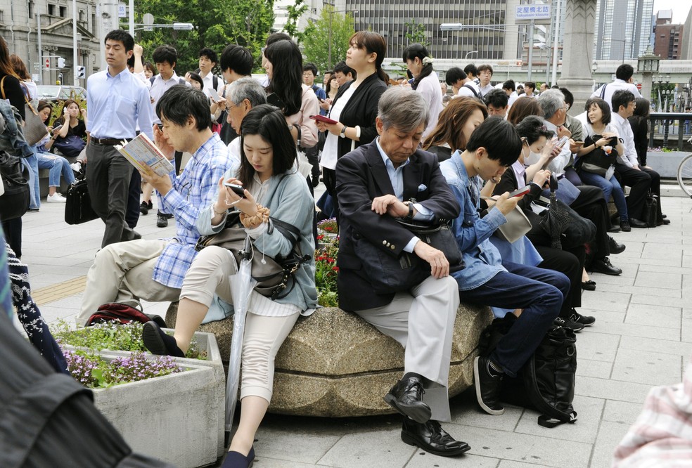 Trabalhadores esperam liberaÃ§Ã£o de estaÃ§Ã£o de trem em Osaka apÃ³s terremoto (Foto: Kyodo/via REUTERS)