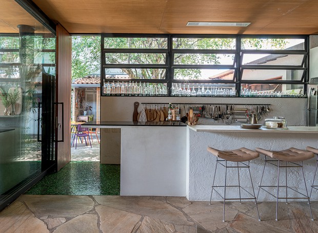 A cozinha tem espaço definido por piso de pastilhas Vidrotil e bancada de concreto. Banquetas altas Bienal, feitas para a mostra comemorativa de 50 anos, à venda na FJ Pronto pra Levar! (Foto: Victor Affaro / Ediora Globo)