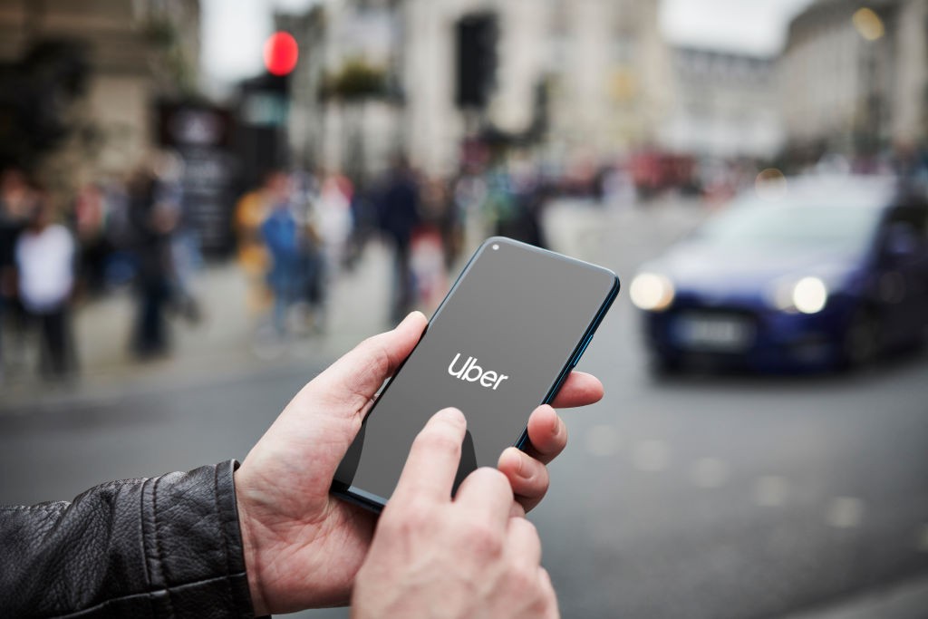 LONDON, UNITED KINGDOM - JUNE 4: Detail of a man holding up an Honor 20 Pro smartphone with the Uber transport app visible on screen, while taxis queue in the background, on June 4, 2019. (Photo by Olly Curtis/Future via Getty Images via Getty Images) (Foto: Future via Getty Images)