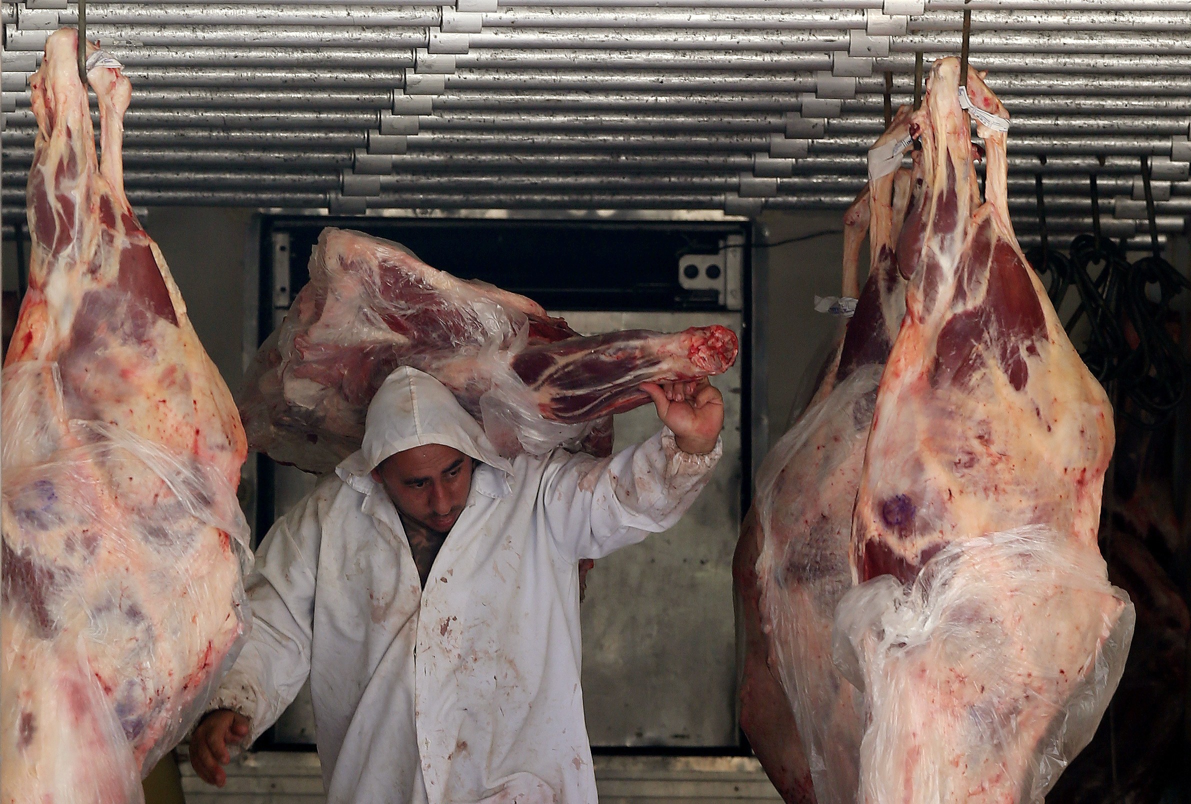 Trabalhador descarrega carne em açougue  (Foto: REUTERS/Paulo Whitaker)
