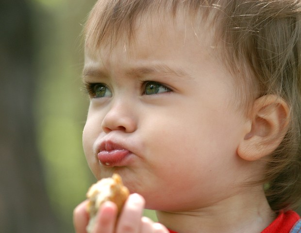 Criança comendo com a boca fechada (Foto: Shutterstock)