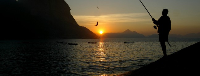 A visão privilegiada de quem acorda cedo para pescar na Baía de Guanabara — Foto: Custodio Coimbra/Agência O Globo