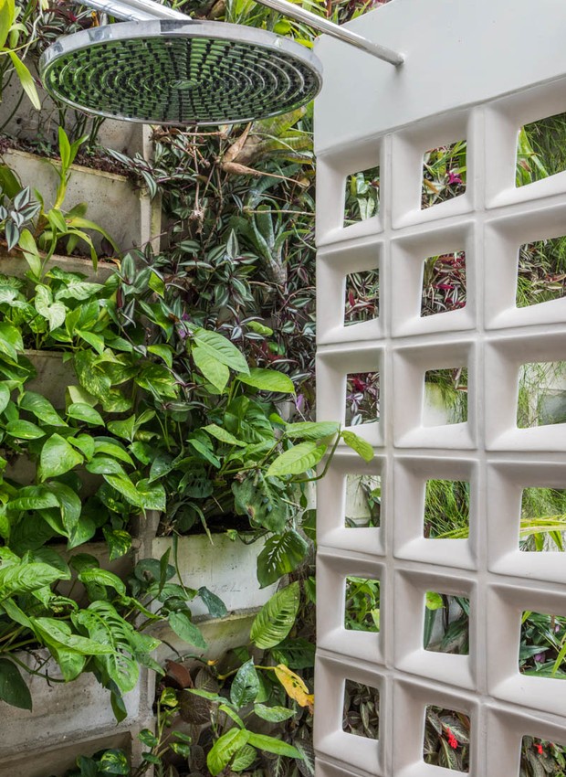 Plantas e uma parede de cobogós dão privacidade ao chuveirão ao lado da piscina (Foto: André Nazareth/ Divulgação)