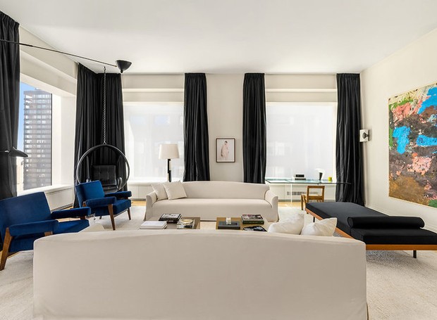 Na sala de estar, o azul marinho se sobressai entre as cores dos móveis (Foto: Mansion Global/ Reprodução)