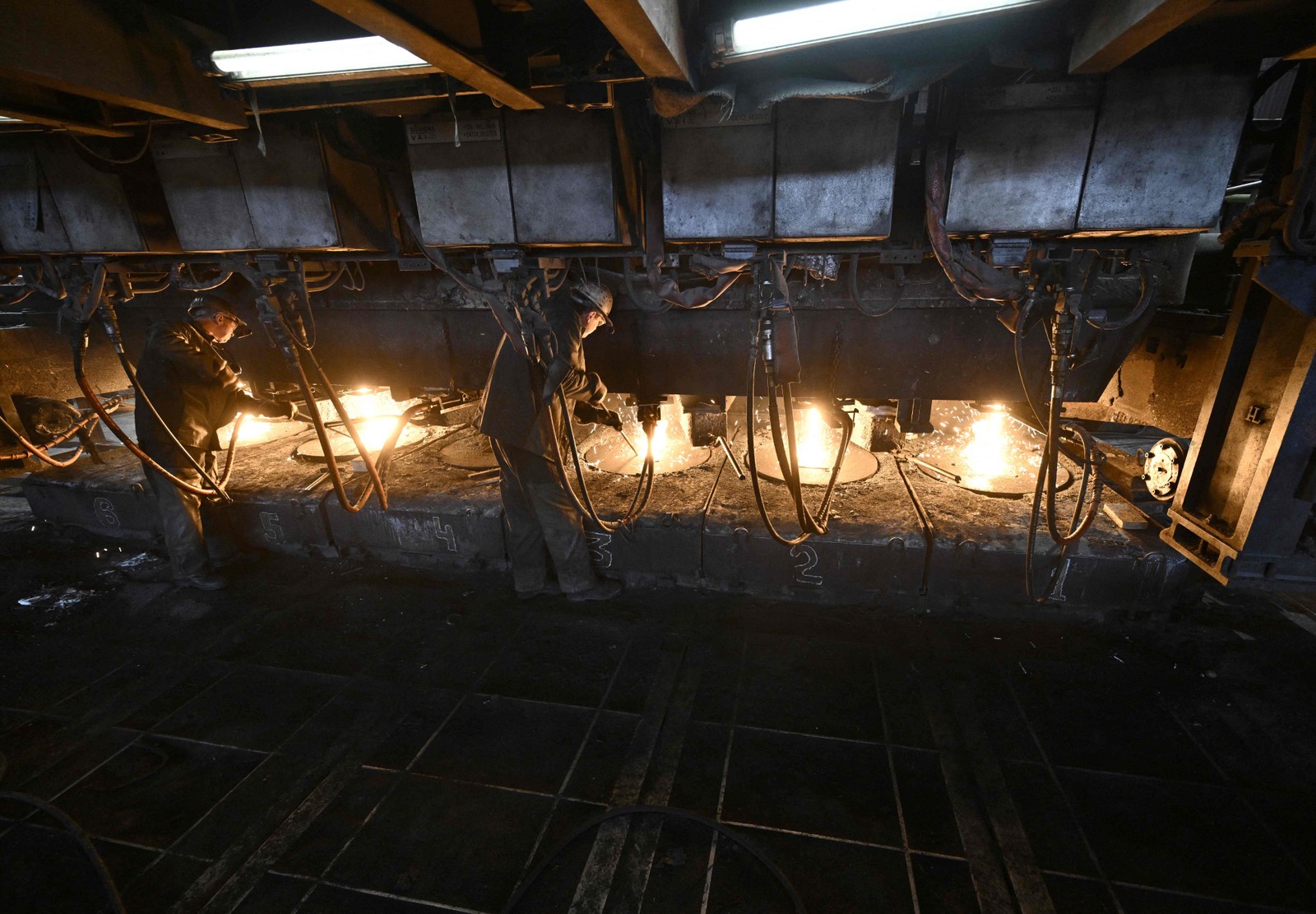 Funcionários trabalham em uma fábrica da companhia siderúrgica integrada ArcelorMittal Kryvyj Rih, na cidade de Kryvyj Rih, no centro da Ucrânia — Foto: Genya SAVILOV / AFP
