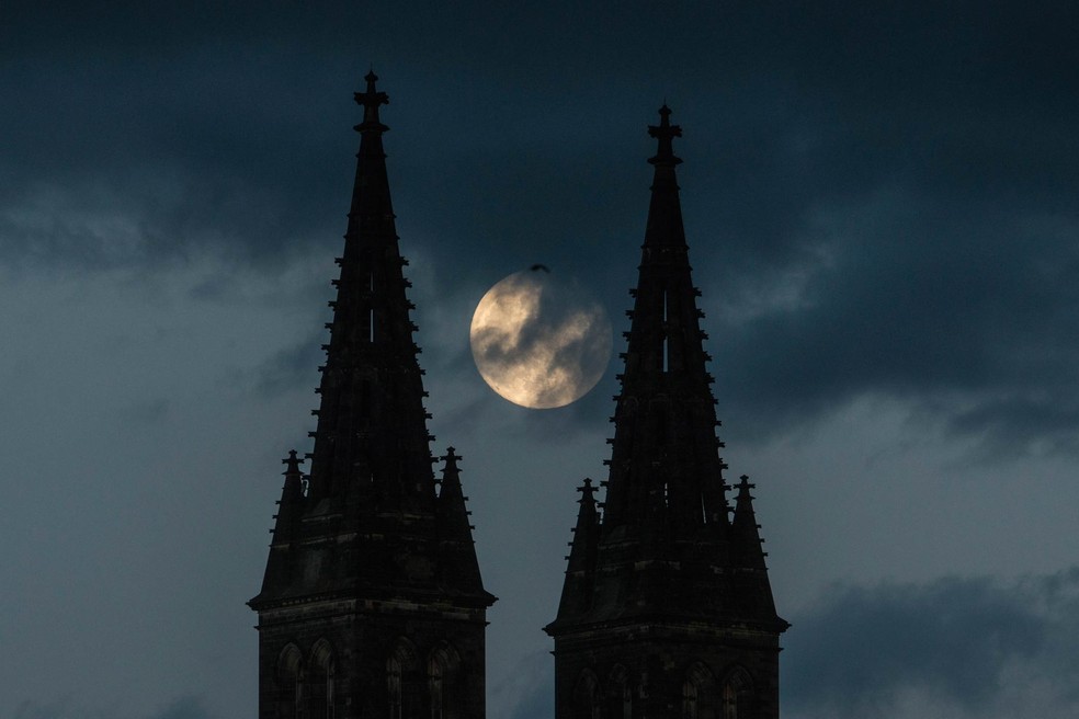 Superlua vista entre as torres da Basílica de São Pedro e São Paulo, em Praga, na noite deste 25 de maio. — Foto: Michal Cizek / AFP