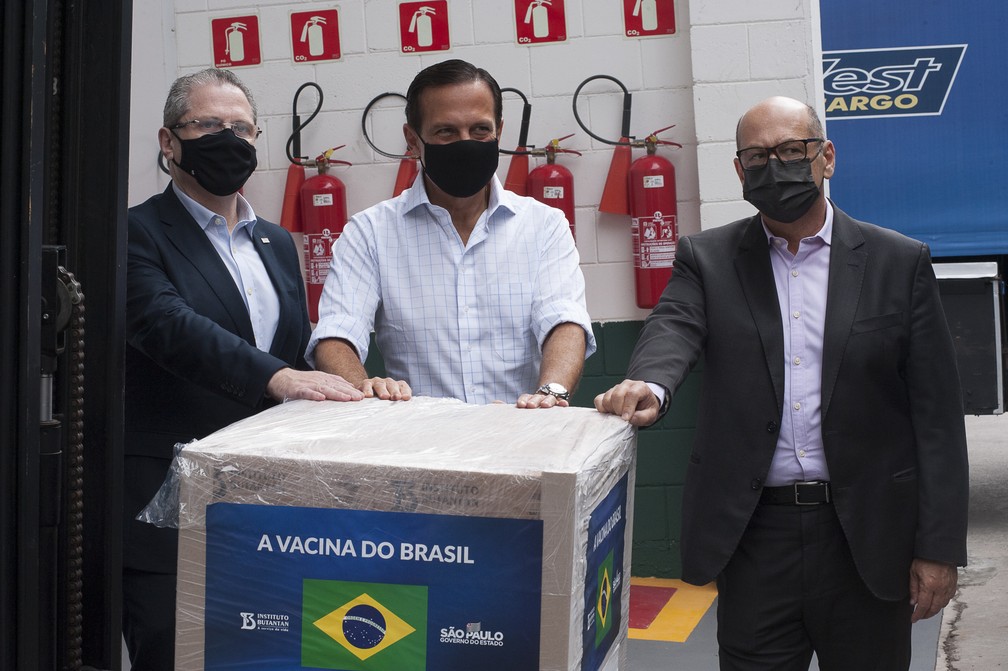 O secretário de Saúde, Jean Gorinchteyn, o governador de São Paulo, João Doria (PSDB), e o diretor do Instituto Butantan, Dimas Covas, acompanham a liberação de 2 milhões de doses da CoronaVac ao Programa Nacional de Imunizações (PNI) do Ministério da Saúde nesta sexta-feira (19) — Foto: Mister Shadow/ASI/Estadão Conteúdo