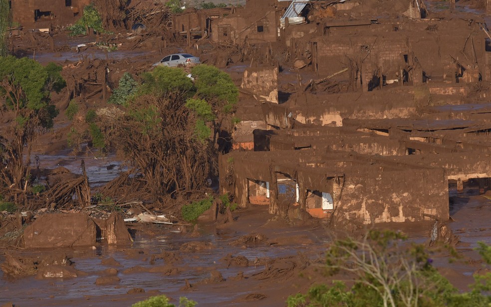 Carros e casas vistos em meio a lama apÃ³s o rompimento da barragem de rejeitos da mineradora Samarco no Distrito de Bento Rodrigues (Foto: Douglas Magno/AFP)