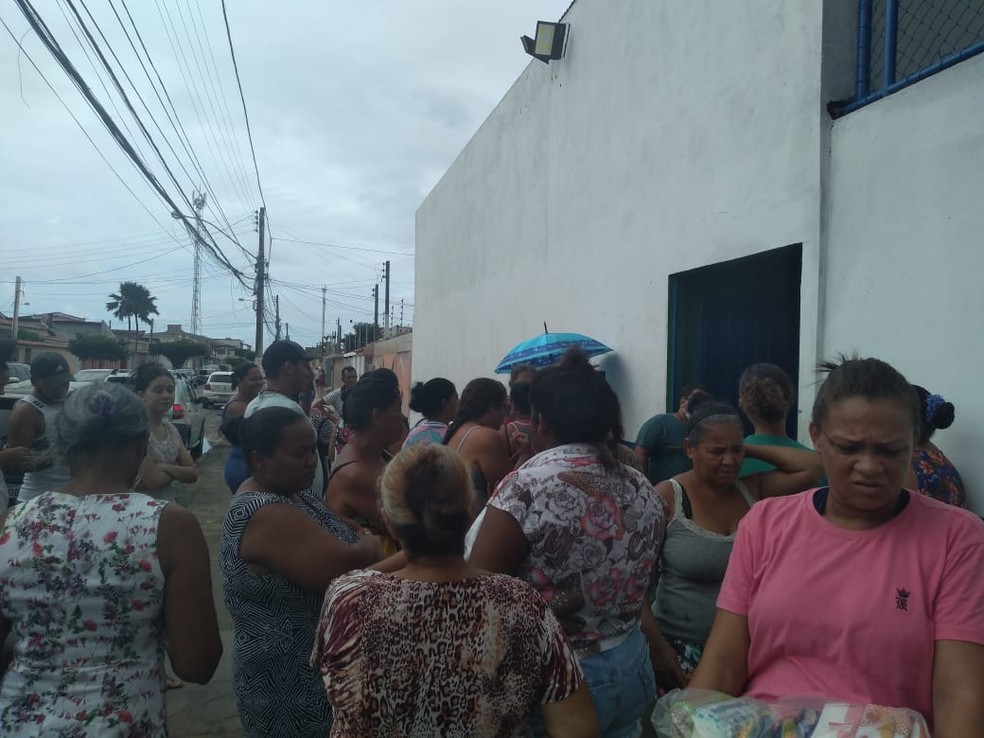 Mesmo recebendo fichas, pais se aglomeraram na porta de escola para receber kit merenda em Maceió — Foto: Carolina Sanches/G1