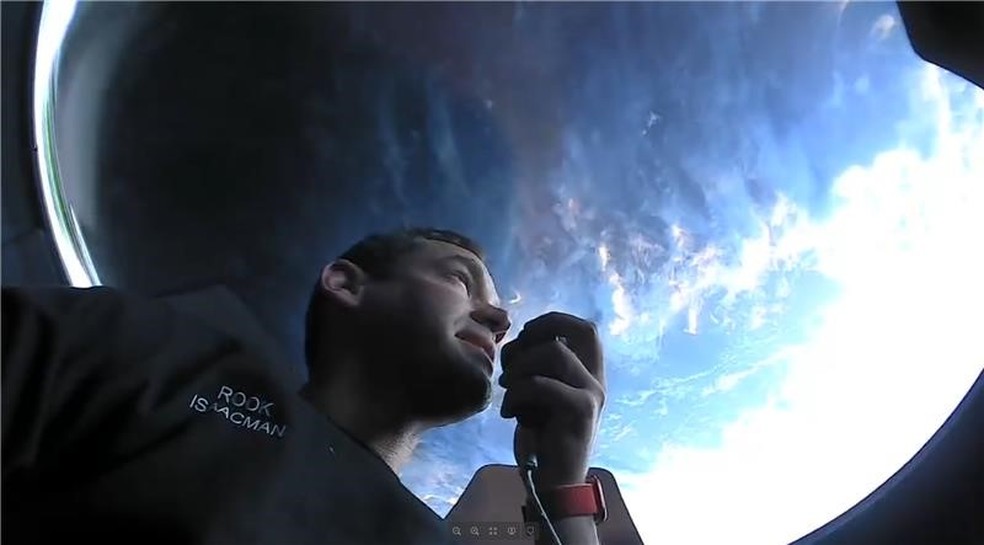 Jared Isaacman, bilionário que bancou a missão, olhando para a Terra através do domo da cápsula — Foto: Redes sociais/Inspiration4
