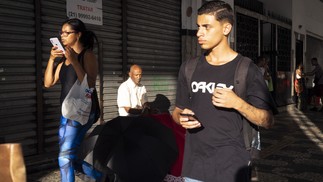 Ao fundo, o sol ilumina o vendedor de guarda-chuvas Ubiratan da Costa, recém-recuperado de um câncer na garganta — Foto: Marcio Menasce