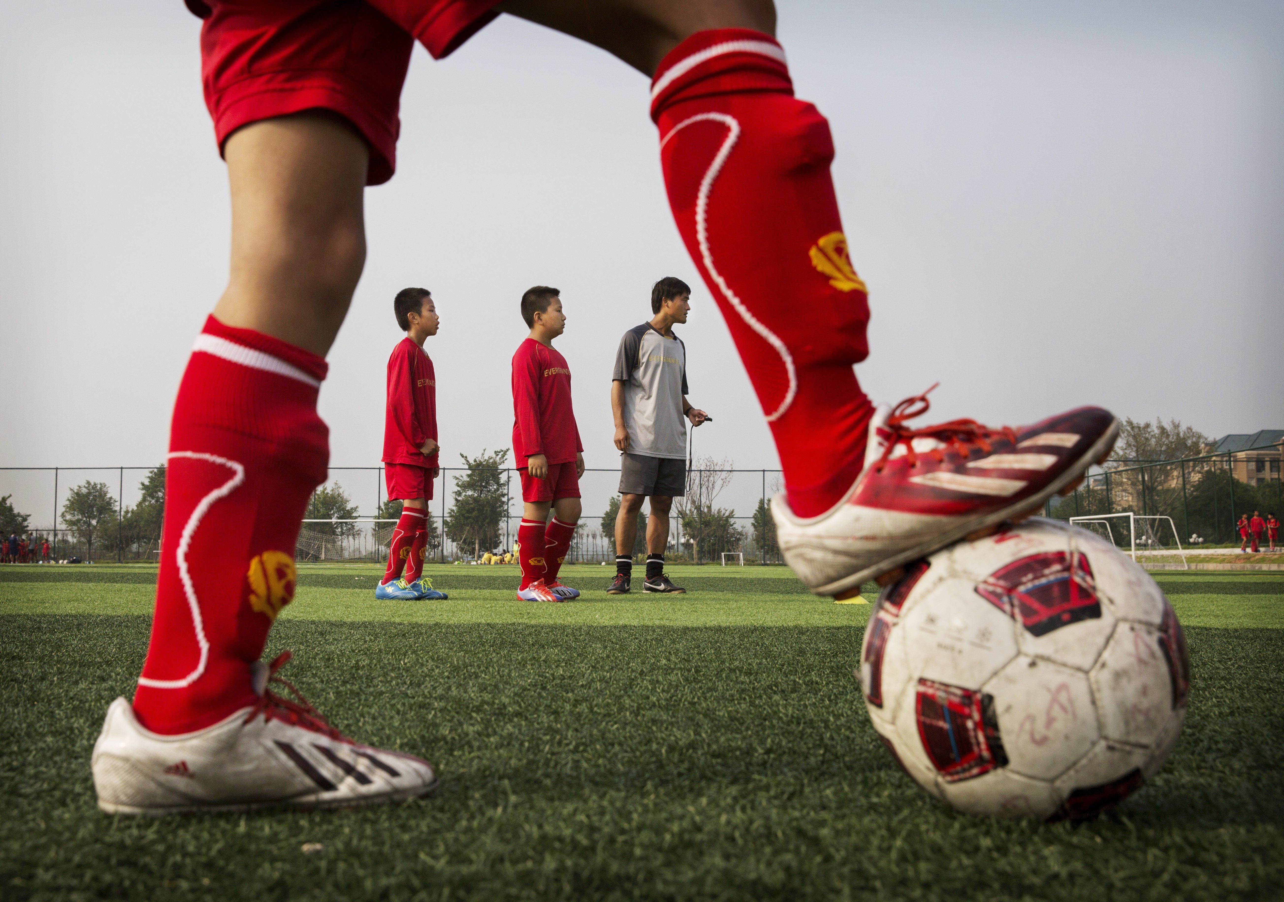 Crianças aprendem futebol na Evergrande International Football School  (Foto: Getty Images)