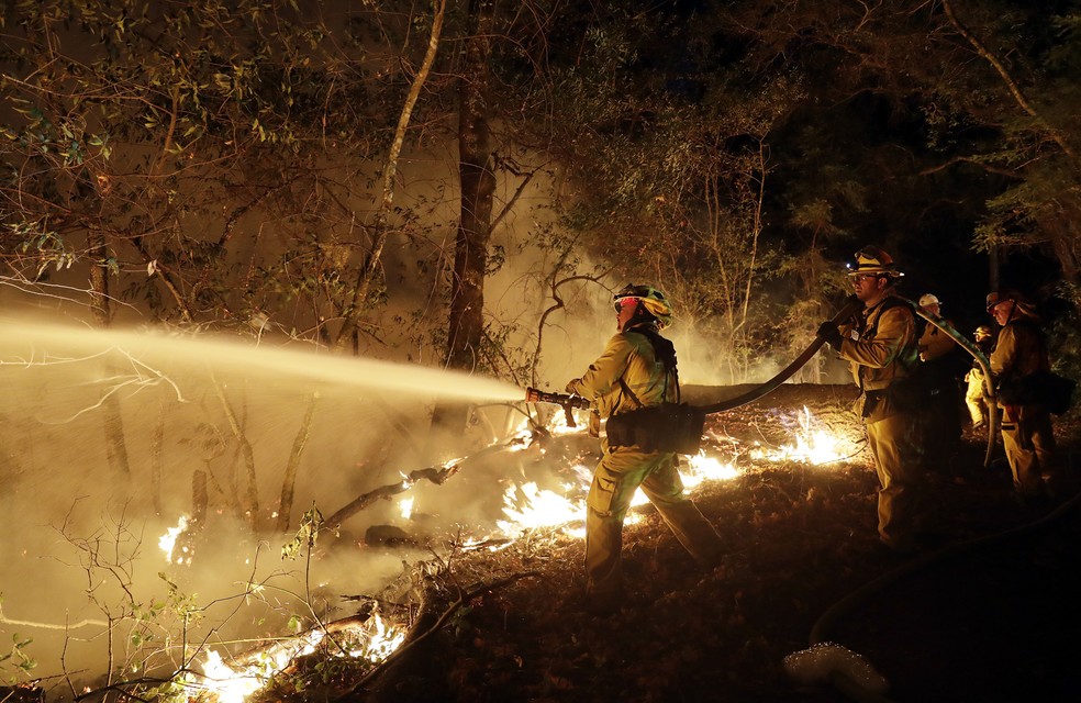 Bombeiro tenta combater fogo em Santa Rosa, na Califórnia (EUA) (Foto: AP Photo/Marcio Jose Sanchez)