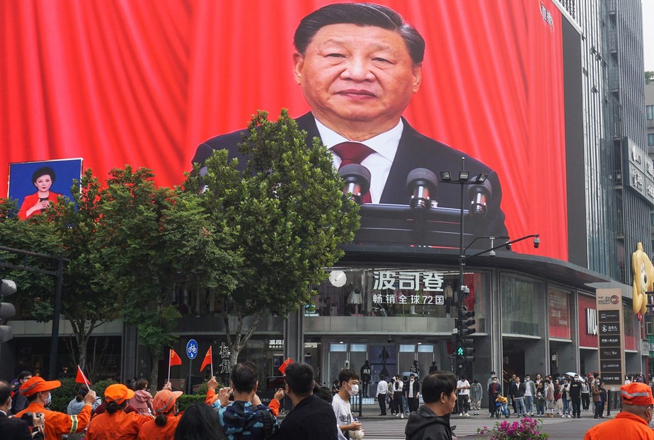 Pessoas observam telão que transmite discurso de Xi Jinping, em Hangzhou