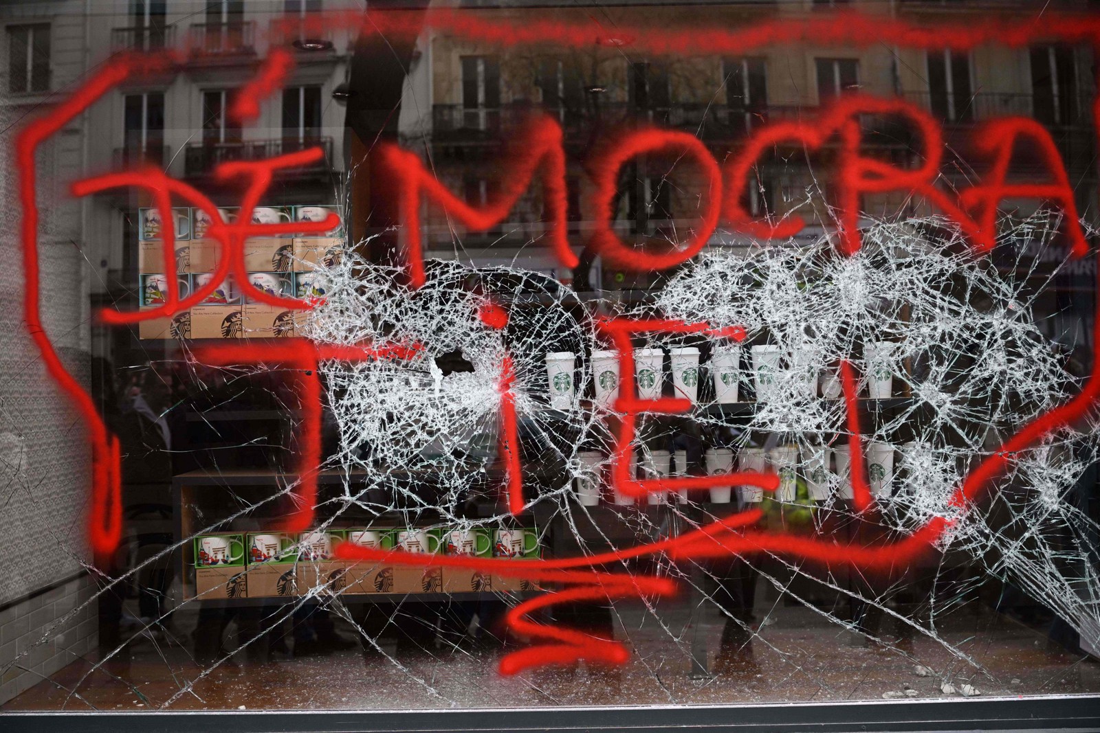 Vitrine de uma loja em Paris foi pichada com a palavra "Democracia" — Foto: Emmanuel Dunand/AFP
