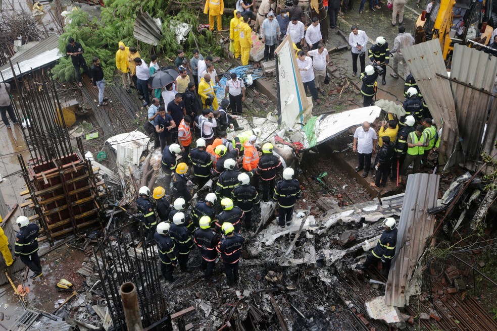 Equipes de resgate fazem buscas entre os destroÃ§os de aviÃ£o que caiu em Mumbai, na Ãndia, nesta quinta-feira (28)  (Foto: Rajanish Kakade/AP)