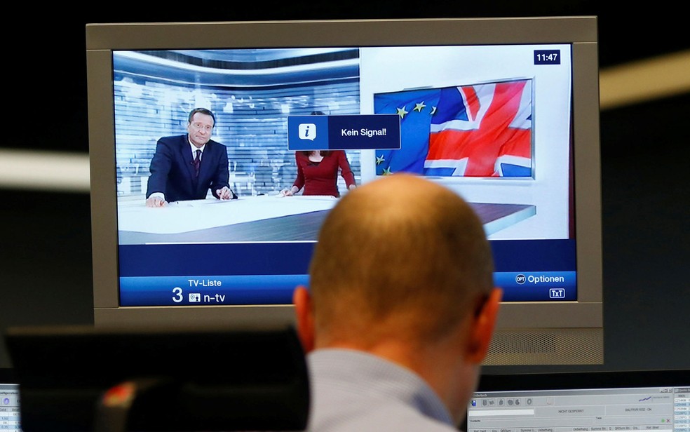 Comerciante trabalha em frente a um noticiário de uma televisão na bolsa de Frankfurt, na Alemanha — Foto: Ralph Orlowski/ Reuters