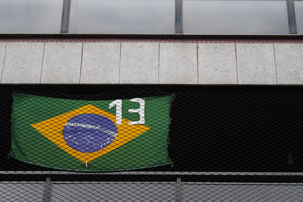 Morador exibe a bandeira do Brasil com o número 13 do Partido dos Trabalhadores — Foto: Marcos Serra Lima/g1