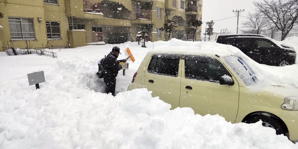 Homem tenta tirar neve de seu carro em Hokkaido, no norte do Japo, em 24 de dezembro de 2022.  Foto: Kyodo via Reuters