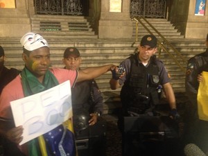 Homem segura cartaz pedindo aprovação da PEC 300 e recebe apoio de policial (Foto: Luís Bulcão/G1)