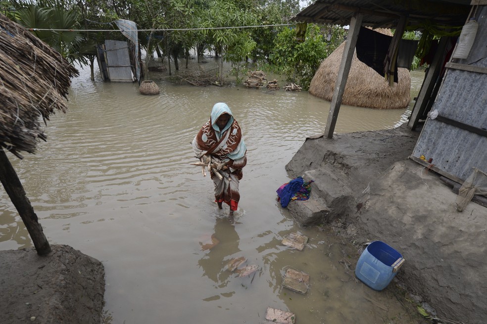 Mulher atravessa área alagada após passagem do ciclone Bulbul em Koyra, Bangladesh — Foto: MUNIR UZ ZAMAN / AFP