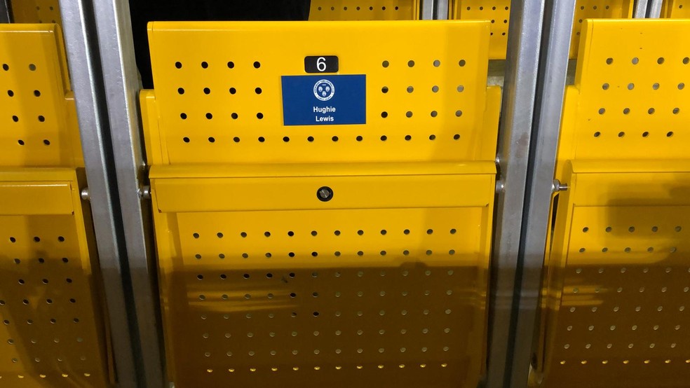 No detalhe: assentos do safe standing são travados. No Shrewsbury, homenageiam quem contribuiu na vaquinha — Foto: Marina Izidro