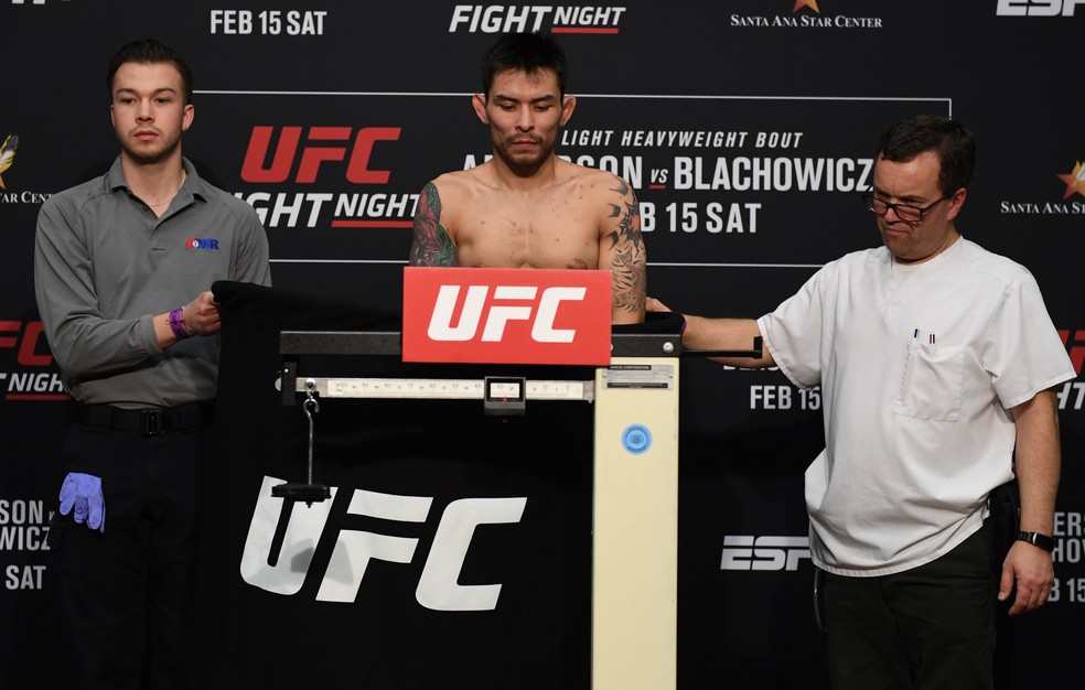 Ray Borg se pesa coberto por um biombo; mesmo assim, não conseguiu bater o peso — Foto: Josh Hedges/Getty Images