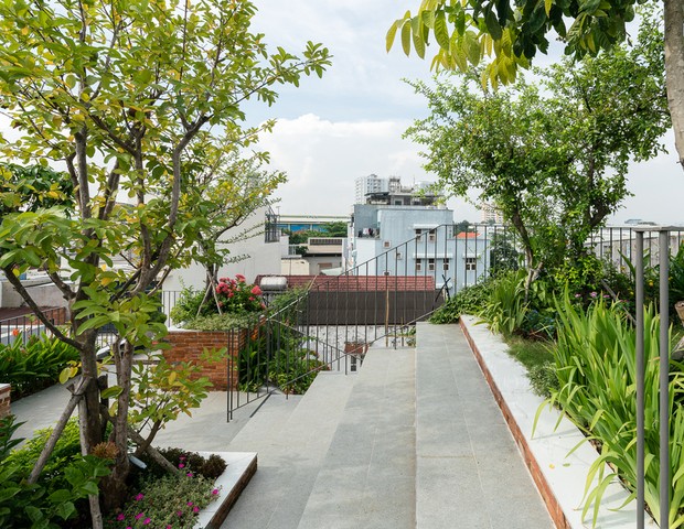 Casa no Vietnã tem 'parque' na cobertura e varandas internas com plantas no living (Foto: Quang Tran / Divulgação)