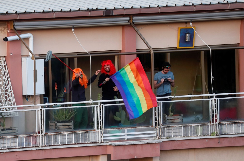 Pessoas acenam das varandas de seus apartamentos enquanto ocorre um flashmob durante o isolamento para conter o avanço do coronavírus em Roma, na Itália, em 15 de março  — Foto: Yara Nardi/Reuters