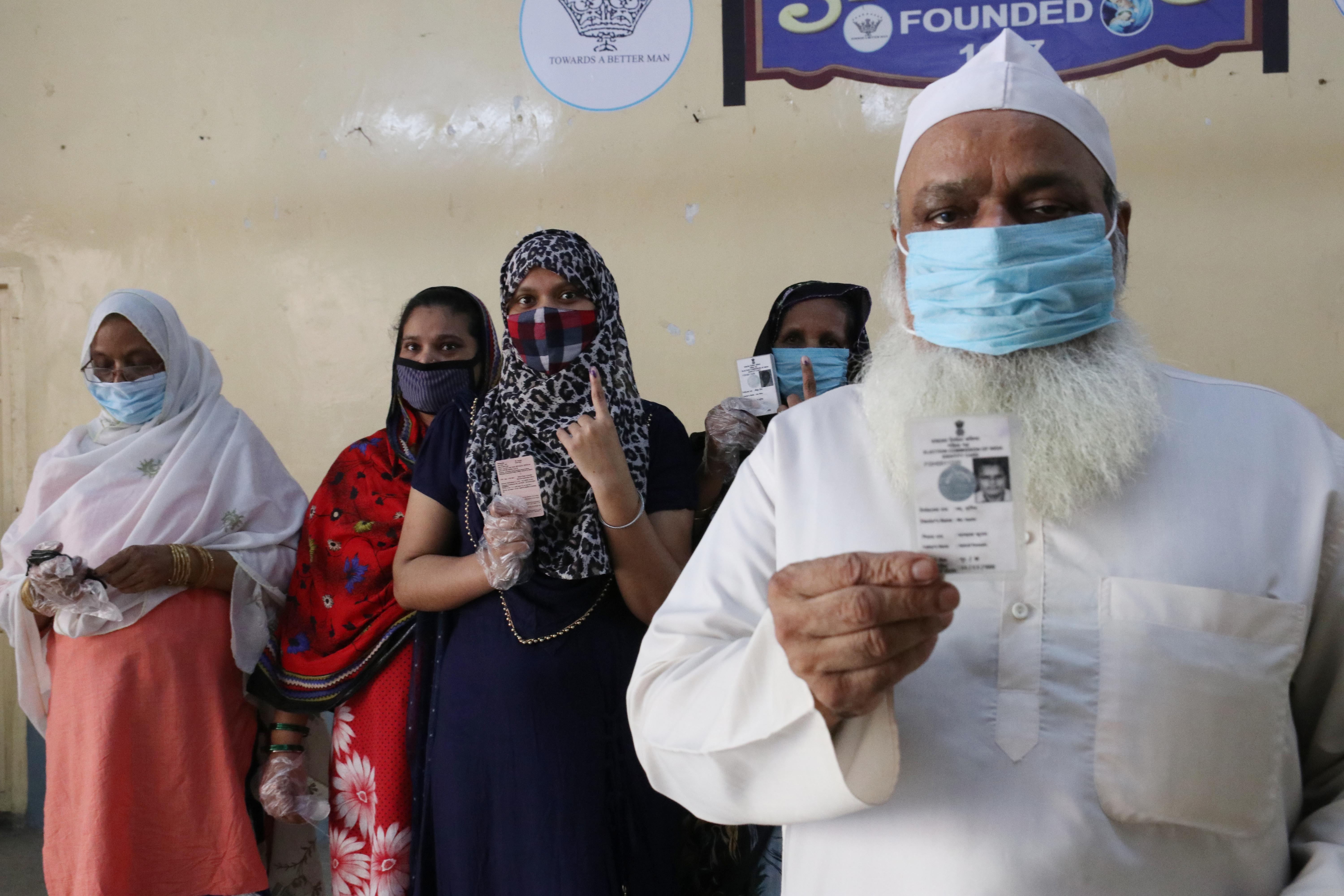 A Muslim family warring protective face mask and showing voter id card wait outside a polling station to cast their vote  during  8th phase of West Bengal assembly elections in Kolkata, India on 29April, 2021. The 8th phase of West Bengal Assembly Electio (Foto: NurPhoto via Getty Images)