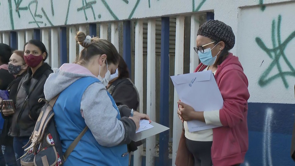 Preenchimento de ficha para entrega de senha em fila da AMA/UBS Jardim São Jorge — Foto: Reprodução/TV Globo