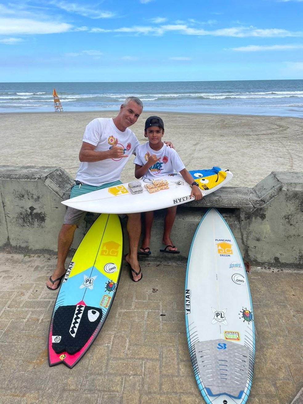 Julio (à esq.) e Bernardo (à dir.) posam com pranchas de surfe — Foto: Projeto Surf Escola, ONG Esporte Vida