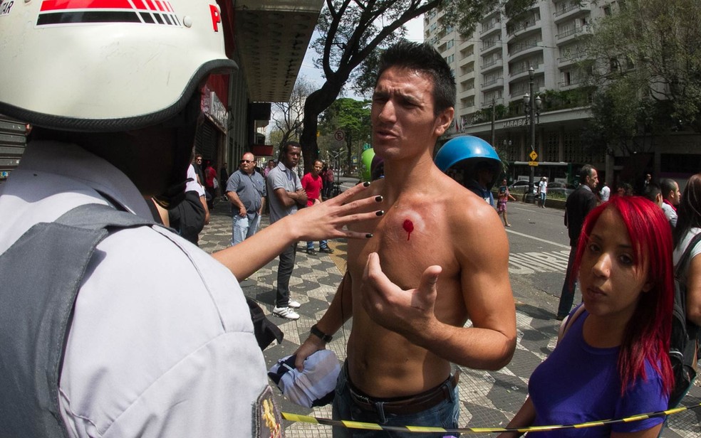 Com ferida de uma bala de borracha no peito, homem conversa com policial em meio a confronto no Centro de São Paulo em 2014 — Foto: Dario Oliveira/Código19/Estadão Conteúdo