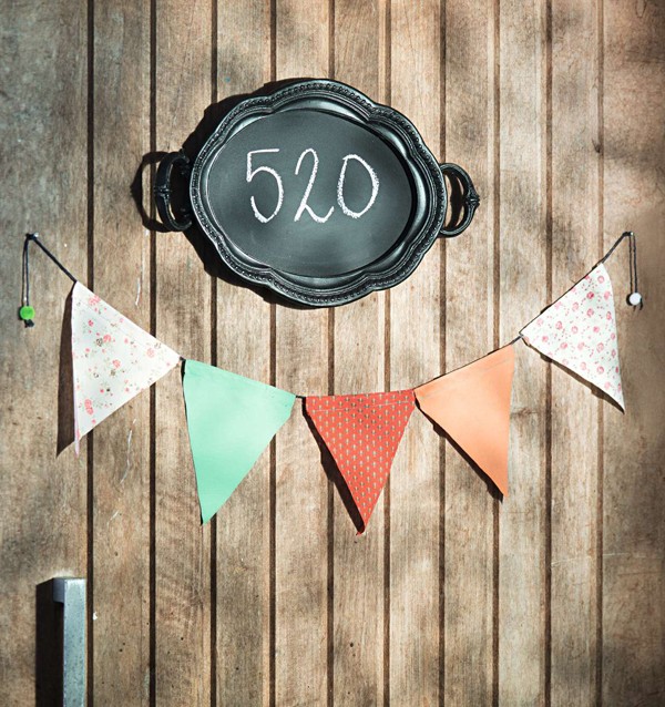 Boas-vindas diferentes: bandeirinhas Botões de Amora na porta e o número da casa escrito na bandeja-lousa Corporação de Ofícios (Foto:  Cacá Bratke/Editora Globo)