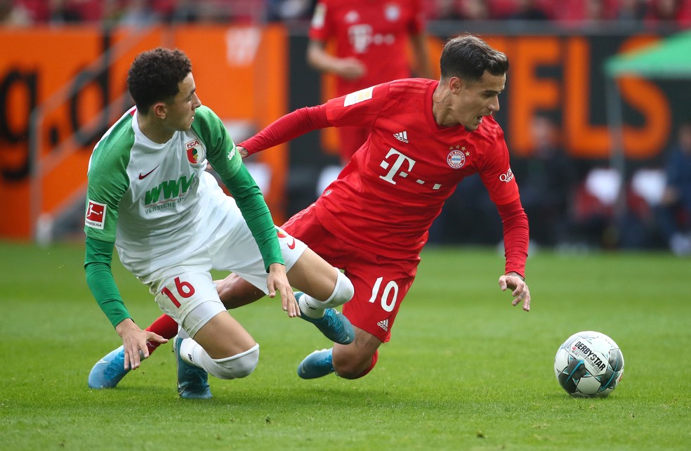 Philippe Coutinho derrubado por Ruben Vargas em Augsburg x Bayern de Munique &mdash; Foto: REUTERS/Michael Dalder 