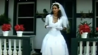 O vestido de Zefa (Giovanna Gold) antigamente era curto, rodado e levava um bolero. Ela também usou luvas — Foto: Reprodução/YouTube