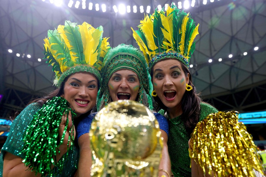 Torcedores do Brasil seguram uma réplica do troféu da Copa do Mundo