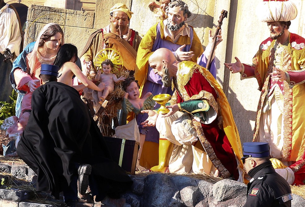 Policiais do Vaticano tentam deter ativista que avançou sobre cenário de Natividade na praça de São Pedro, no Vaticano (Foto: REUTERS / Alessandro Bianchi)