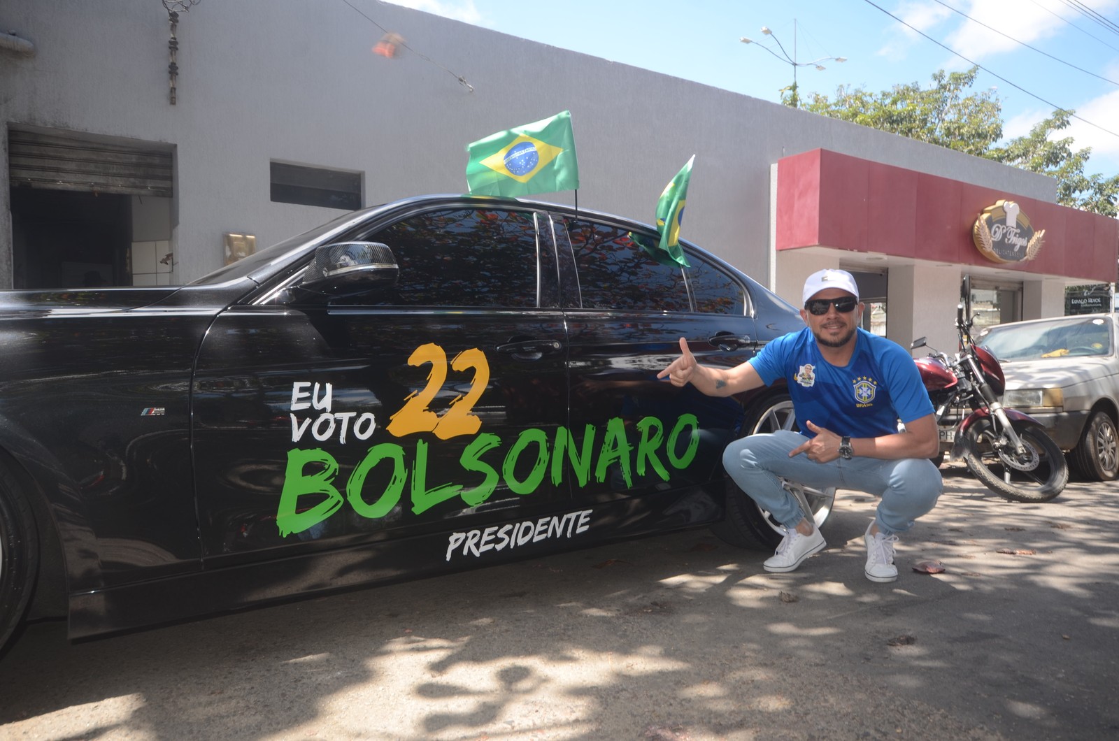 Apoiador de Bolsonaro ao lado de carro que estampa número do presidente nas urnas, em outubro — Foto: Genival Paparazzi/Agência O Globo 