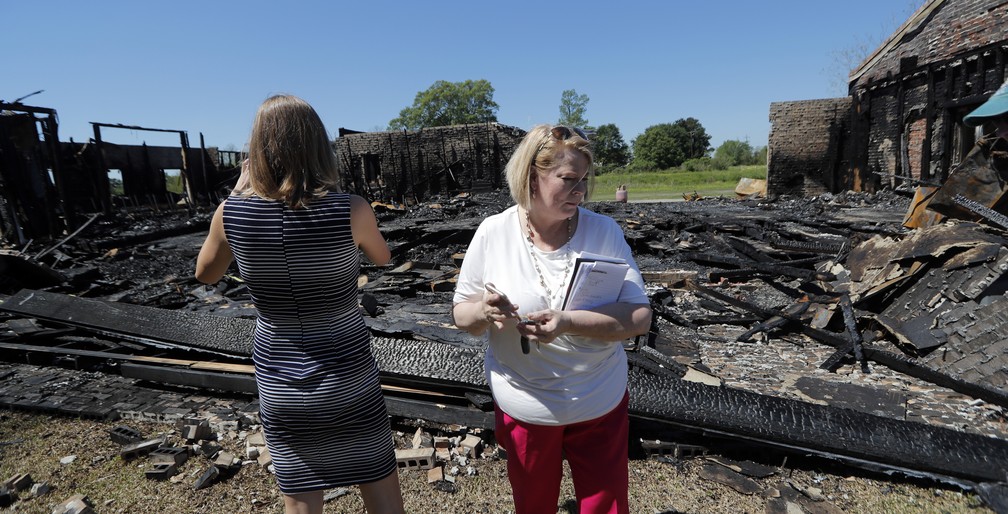 Funcionárias de organização beneficente examinam ruínas de uma das igrejas destruídas em incêndio em Louisiana, nos EUA — Foto: Gerald Herbert/AP Photo