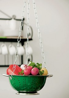 Com um escorredor e correntes para vasos, você monta em um instante um suporte para deixar legumes e outros ingredientes à mão na hora de preparar as receitas. O acessório também pode ser usado como uma fruteira suspensa