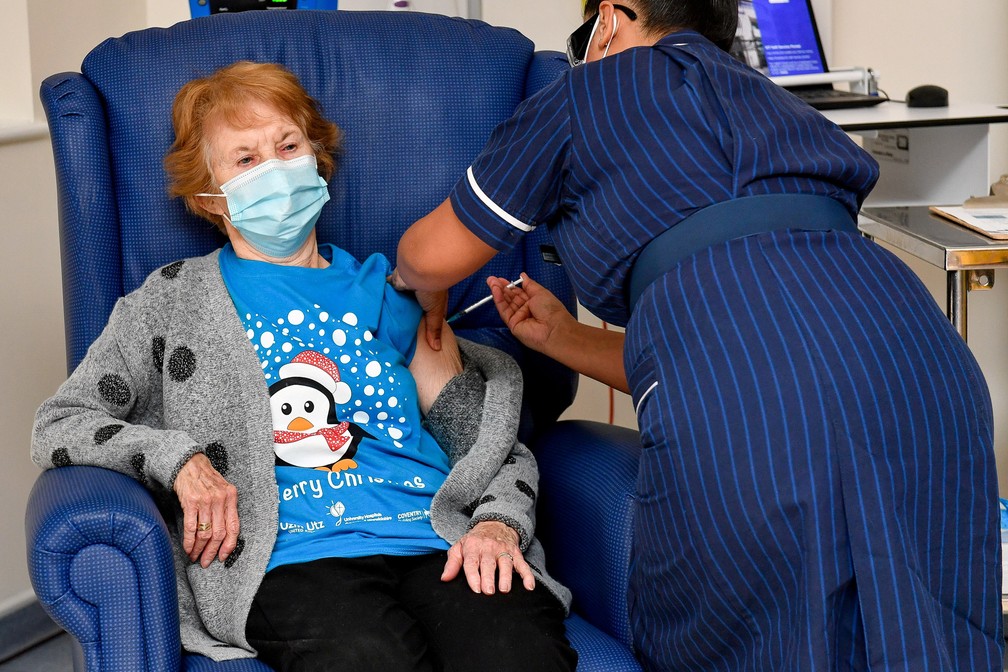 8 de dezembro - A britânica Margaret Keenan, de 90 anos, recebe dose da vacina contra Covid-19 em um hospital de Coventry, na região central da Inglaterra. Ela foi a primeira a receber a vacina da farmacêutica norte-americana Pfizer e da empresa alemã de biotecnologia BioNTech no Reino Unido — Foto: Jacob King/pool via Reuters
