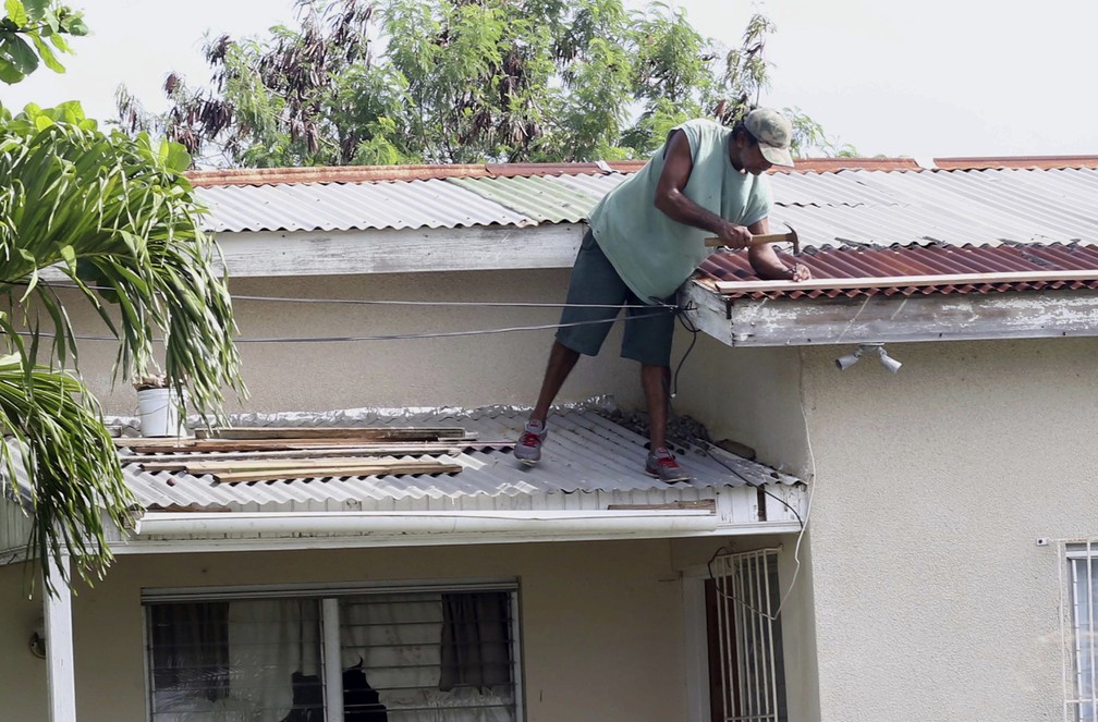 Homem faz pequenos reparos em telhado de casa antes da passagem do furacão Irma em  St. John's, Antigua e Barbuda (Foto: AP Foto/Johnny Jno-Baptiste)